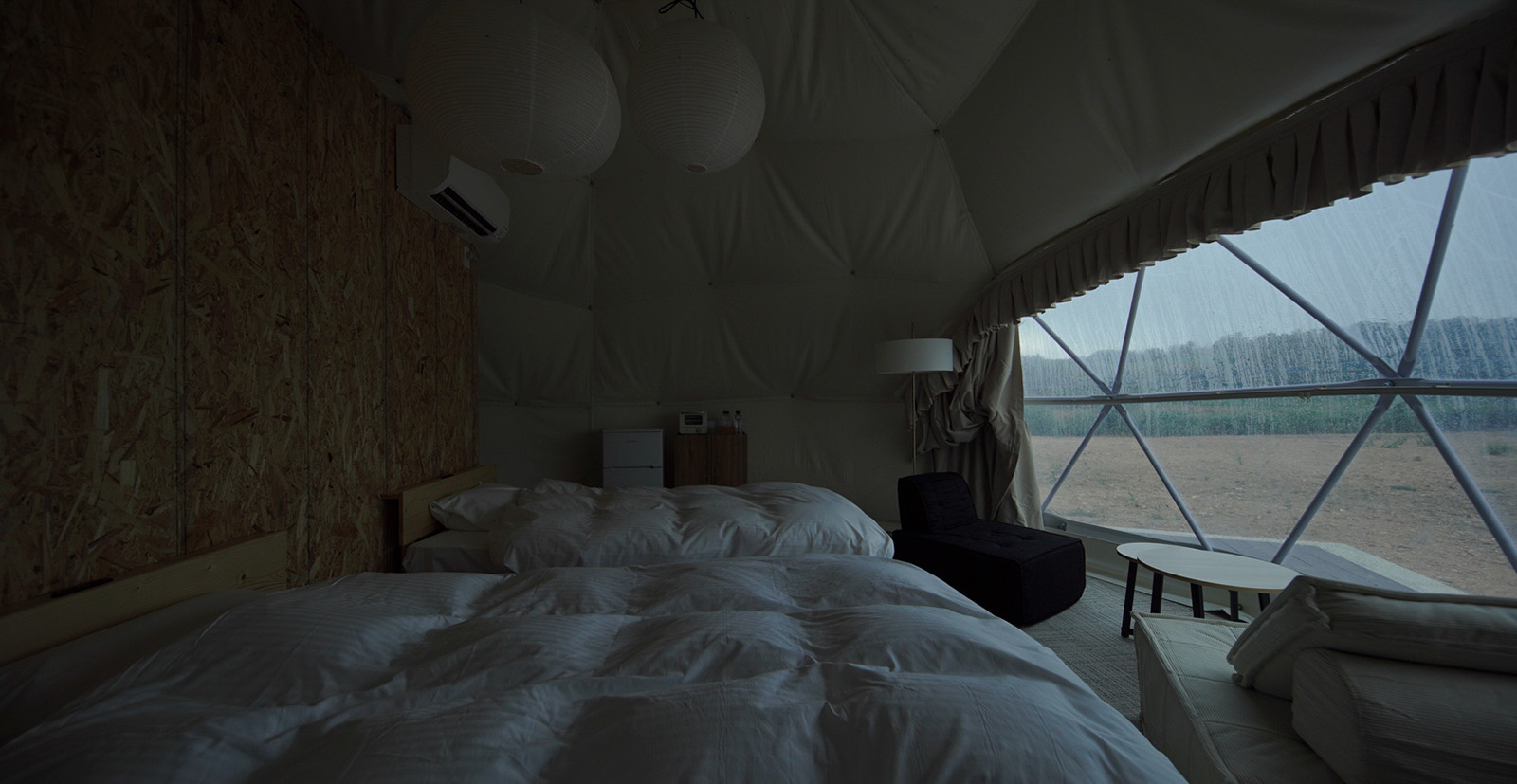 グランメモリー夏泊の客室内部、海を望む大きな窓とベッド